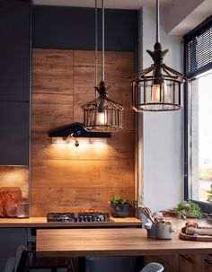 a kitchen with some lights hanging from the ceiling and wooden counter tops in front of a window