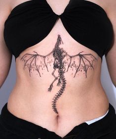 a woman with a dragon tattoo on her stomach is shown from the waist to the back