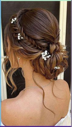 the back of a woman's head with white flowers in her hair and braid