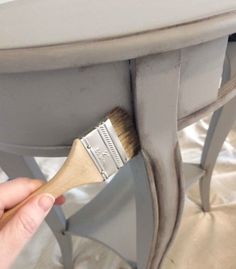 a person holding a paint brush under a table