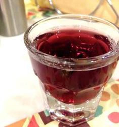 a glass filled with liquid sitting on top of a table