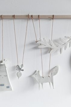 three ornaments hanging on a wall next to a clock and other items in the shape of animals