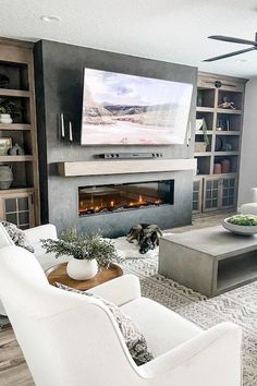 a living room filled with furniture and a flat screen tv mounted on the wall above a fireplace