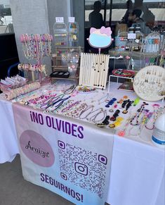 there is a table that has many items on it for sale in the store, including bracelets and necklaces