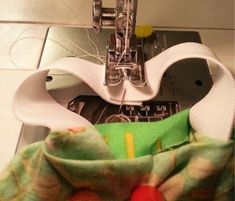 the sewing machine is next to an apple on top of some material that has been sewn