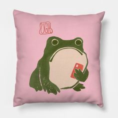 a pink pillow with a green frog holding a cell phone in it's hand