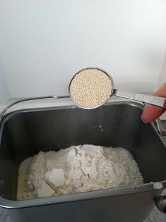 a person is measuring the amount of flour in a metal pan with a measuring tape