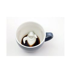 a cup filled with liquid and a small white animal in it