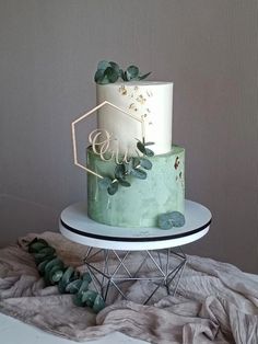 a green and white cake sitting on top of a table next to some plants in front of a wall