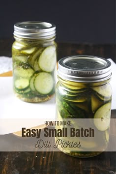 two jars filled with pickles sitting on top of a table