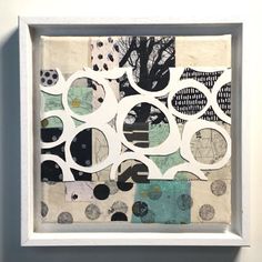 an art piece is displayed in a white frame with black and white circles on it