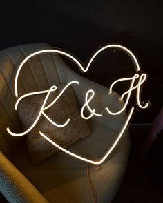 a heart shaped neon sign sitting on top of a chair