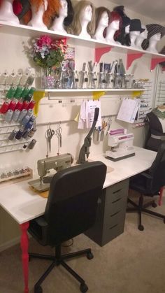 a room with several different types of hats on the wall and two desks in front of them