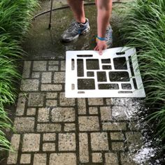 a person standing next to a patch of grass with a keyboard cut out on it