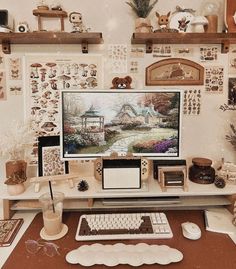 a desk with a computer, mouse and other items on it in front of a wall full of pictures