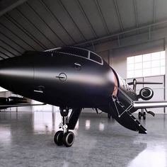 an airplane is parked in a hangar with its door open and it's wheels still on the ground