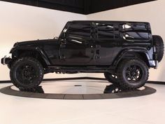 a black jeep is on display in a showroom