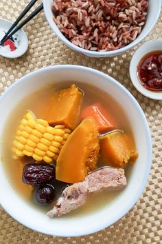 a bowl filled with meat and vegetables next to two bowls of food on a table