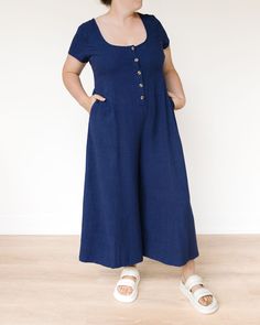 This stylish and versatile linen button-down jumpsuit, is perfect for effortless chic looks on warm days. This jumpsuit features a flattering scoop neck that adds a touch of femininity to the overall design. The button-front closure allows for easy dressing and adds a classic touch to the jumpsuit's aesthetic. With short sleeves, this jumpsuit offers comfort and breathability, making it ideal for summer outings or casual occasions. Equipped with two side pockets, this jumpsuit combines style wit Casual Jumpsuits And Rompers With Button Cuffs, Button Closure Jumpsuits And Rompers For Loungewear, Jumpsuits And Rompers With Button Closure For Loungewear, Casual Button-up Jumpsuits And Rompers With Button Cuffs, Summer Linen Jumpsuits And Rompers With Button Closure, Spring Loungewear Jumpsuits And Rompers With Buttons, Cotton Jumpsuits And Rompers With Buttons For Day Out, Casual Linen Jumpsuits And Rompers With Buttons, Overall Design