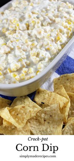 a bowl of corn dip surrounded by tortilla chips on a blue and white towel