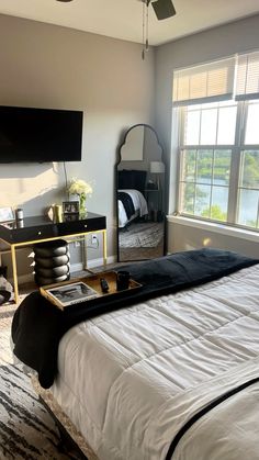 a bedroom with a large bed and a flat screen tv mounted to the wall above it