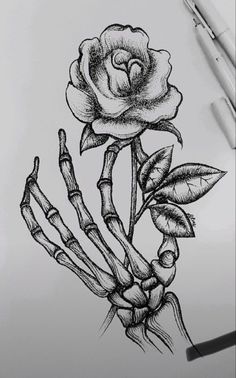 a drawing of a rose and skeleton hands