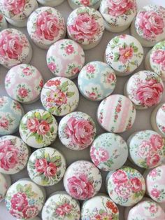 several pink roses on white buttons with green leaves and red flowers in the middle one is surrounded by smaller ones