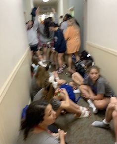 a group of people sitting on the floor in a hallway