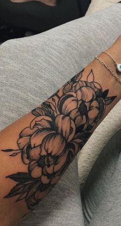 a woman with a flower tattoo on her arm