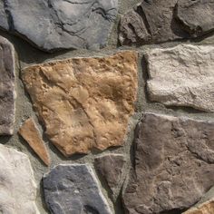 a stone wall with several different colored rocks