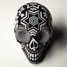 a black and white beaded skull mask on a table