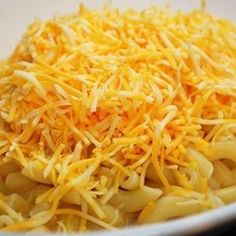 shredded cheese on top of pasta in a white bowl