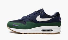 The Women’s Nike Air Max 1 “Obsidian/Gorge Green” is a women’s-only colorway of the retro running shoe from Nike’s “Letterman” pack.  Inspired by vintage varsity letterman jackets and other classic collegiate sportswear, the “Letterman” pack by Nike outfits the brand’s popular silhouettes with old school details.  The “Obsidian/Gorge Green” features an Obsidian nylon base with tonal suede and Gorge Green overlays, the latter of which is featured on the mudguard.  A white leather Swoosh appears o Air Max Outfit, Vintage Varsity Jacket, Retro Running Shoes, Rare Shoes, Vintage Varsity, Varsity Letterman Jackets, Letterman Jackets, Nike Brand, Nike Air Max 1