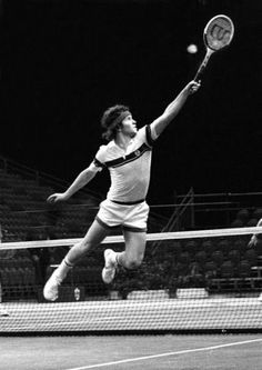 a man jumping in the air to hit a tennis ball