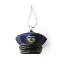 a police hat hanging from a chain on a white wall with an image of a man's face