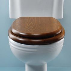 a white toilet with wooden seat and lid