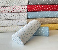 a stack of folded sheets and pillows on a white counter top with stars in them