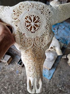 a person is carving an animal's skull with intricate carvings