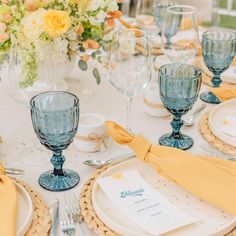 the table is set with yellow napkins and place settings