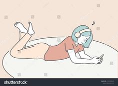 a woman laying on her stomach using a cell phone while listening to music with headphones