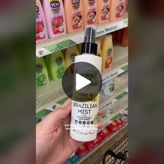 a person holding up a bottle of shampoo in front of a store display shelf