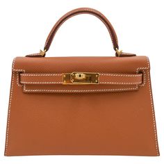 Brand: Hermès Style: Kelly II Sellier Mini Size: 20cm Color: Gold Material: Epsom Leather Hardware: Gold Hardware(GHW) Dimensions: 7.5" W x 4.5" H x 2.25" D Handle Drop: 3.25" Strap Drop: 18.5" Kelly 25 Sellier, Kelly Pochette, Hermes Kelly 25, Kelly 25, Vintage Kelly, Mini Kelly, Hermes Style, Brown Leather Satchel, Mini Gold