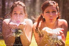 two young women are playing in the water with their hands and face covered by confetti