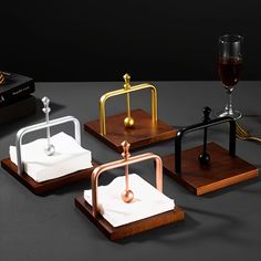 four wooden coasters with metal handles, one holding a wine glass and the other carrying a paper towel