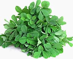 some green leaves are next to a small pile of ground spices on a white background