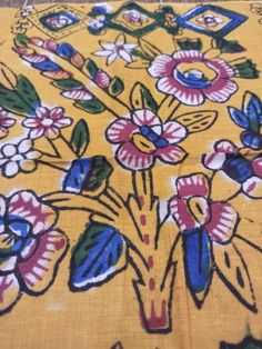 a yellow table cloth with blue and pink flowers on it