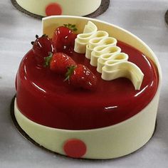 a red and white cake topped with bananas and strawberries next to other desserts