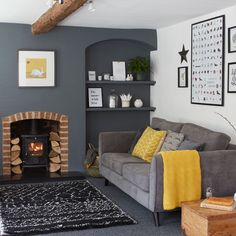 a living room with a couch, fireplace and pictures on the wall above it's mantle