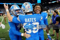 two football players hugging each other on the field