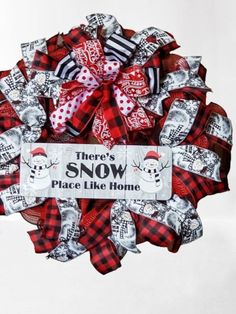 there's snow place like home wreath with red and black plaid ribbon, white background